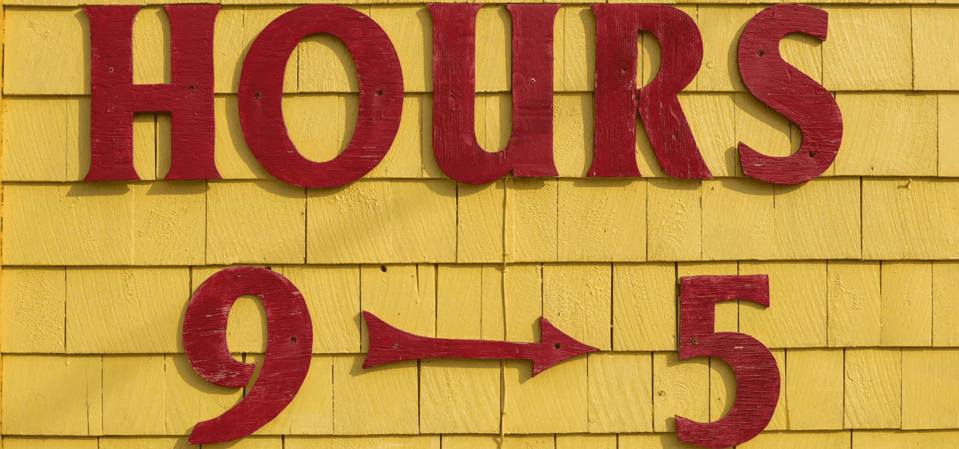 Red sign reading “Hours 9–5” on a yellow background – symbolizing the traditional 9-to-5 work schedule.