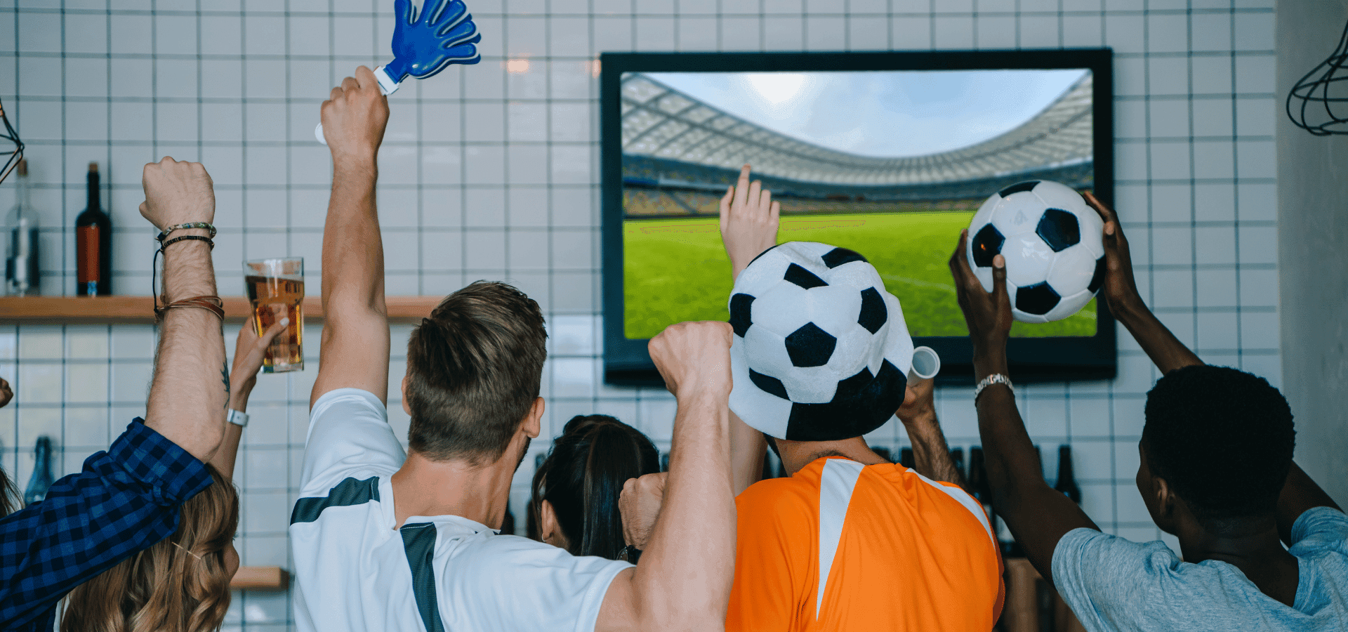 Soccer fans in a kitchen during work, celebrating a game together.