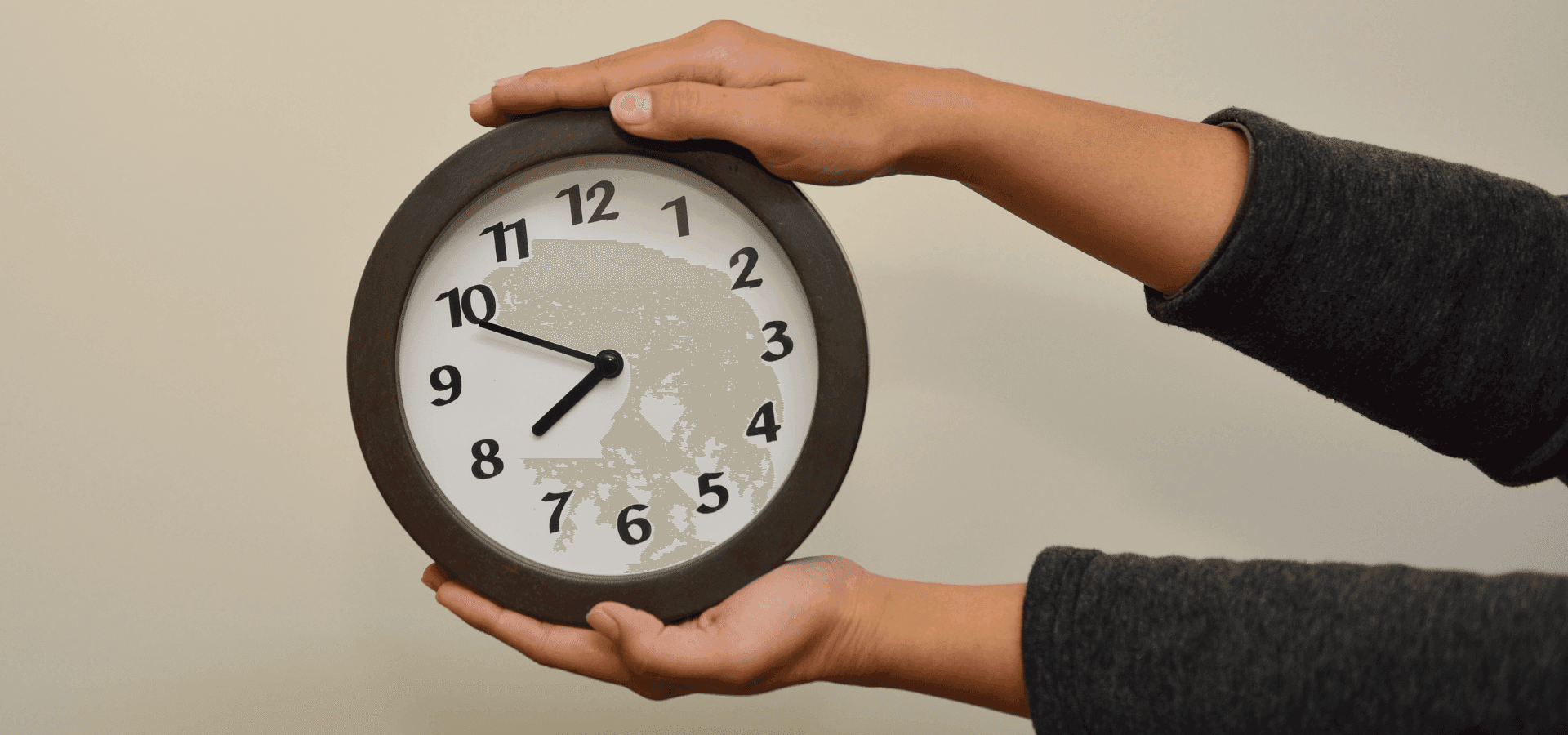 Eine Uhr zwischen zwei Händen, wie ein Sandwich, das Teilzeit- und Vollzeitstellen anzeigt.