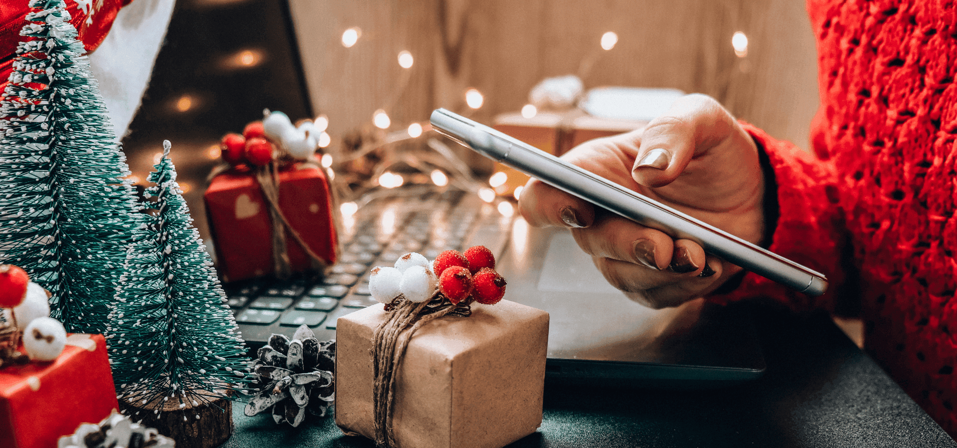 Person using smartphone in home office decorated for Christmas – symbolic image of availability during the Christmas holidays and constant digital presence at work.